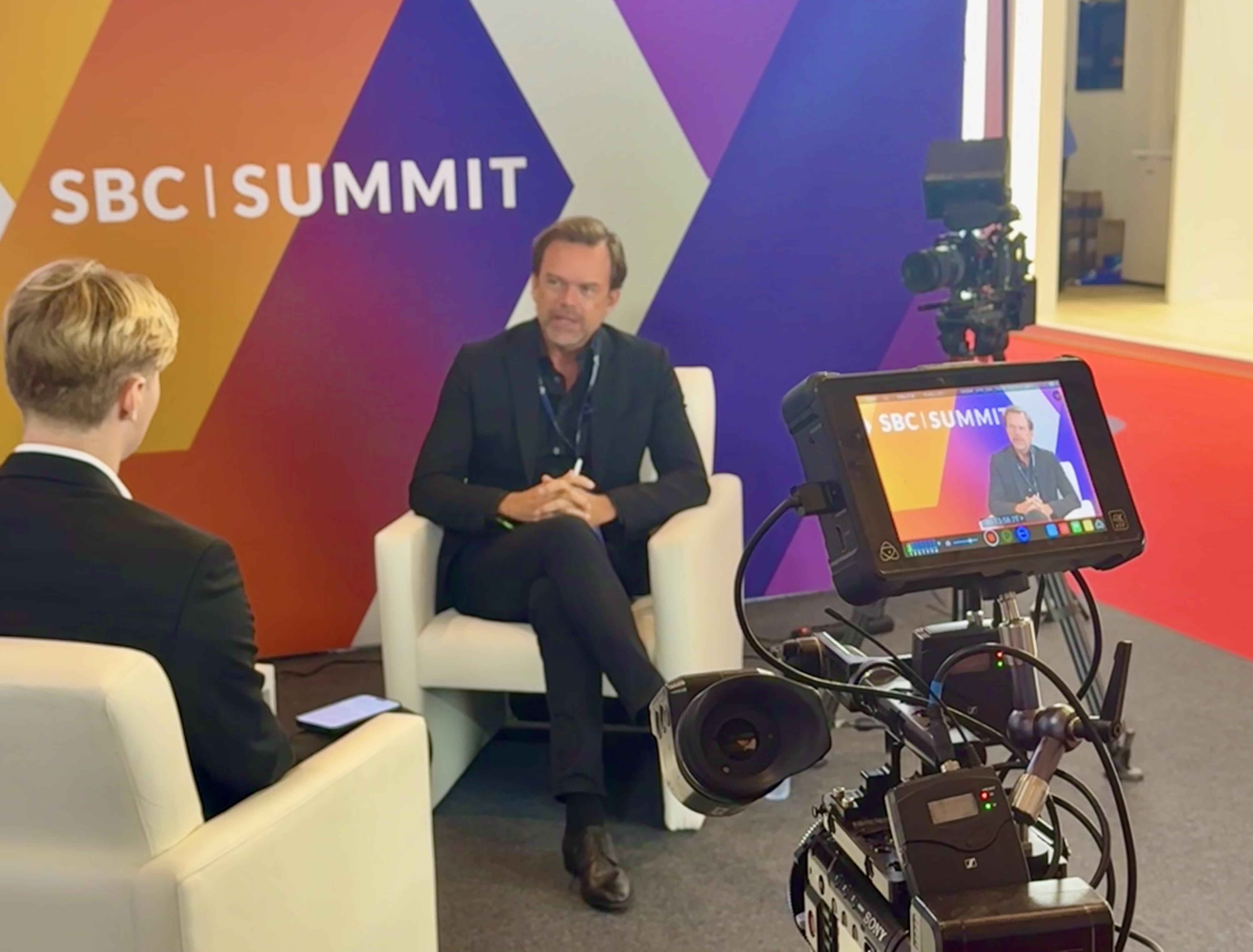 Jonas Reuter discuss in an interview and sits in front of a camera with an interviewer